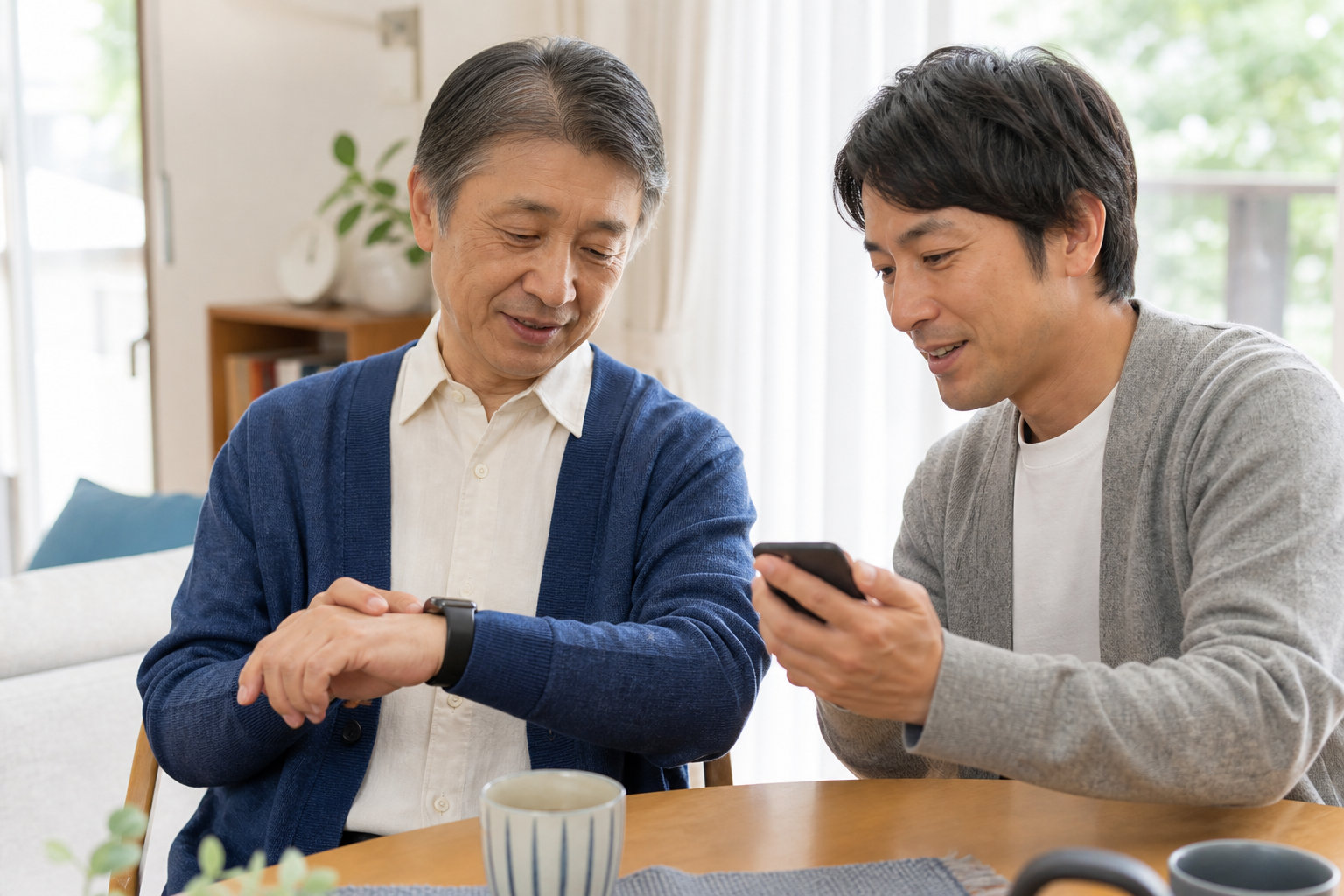 高齢者がスマートウォッチを確認し、家族がスマートフォンで見守り方法を相談している様子
